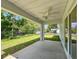 Covered patio with ceiling fan, overlooking a spacious yard with trees, perfect for outdoor relaxation at 2376 Se 40Th Street Road, Ocala, FL 34480