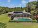 Aerial view of the home with a screened-in pool and solar panels at 26200 Se Highway 42, Umatilla, FL 32784