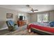 Cozy bedroom featuring wood-look floors, ceiling fan, dresser, and access to the backyard at 26200 Se Highway 42, Umatilla, FL 32784