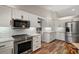 Well-lit kitchen with stainless steel appliances, white cabinets, subway tile backsplash, and wood-look flooring at 26200 Se Highway 42, Umatilla, FL 32784