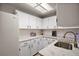 Bright kitchen featuring white cabinets, stainless steel sink, subway tile backsplash, and marble countertops at 26200 Se Highway 42, Umatilla, FL 32784