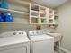 Functional laundry room with washer, dryer, utility sink, and built-in shelving at 26200 Se Highway 42, Umatilla, FL 32784
