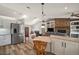 Open-concept living space featuring a stone fireplace, modern kitchen, and wood plank flooring at 26200 Se Highway 42, Umatilla, FL 32784