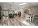 Open-concept living area with wood flooring, natural light, and a dining space with stylish lighting at 26200 Se Highway 42, Umatilla, FL 32784