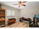 Functional home office with wood-look flooring, ceiling fan, and natural light from the window at 26200 Se Highway 42, Umatilla, FL 32784