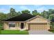 Charming single-story home with a two-car garage, complemented by a well-maintained lawn and tidy landscaping at 3107 Ne 46Th Ave, Ocala, FL 34470