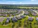 The aerial view shows a neighborhood of attractive homes with verdant lawns and mature trees under a partly cloudy sky at 3587 Nw 55Th Cir, Ocala, FL 34482