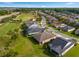 Aerial view showcases well-maintained homes and green landscapes adjacent to a scenic golf course and roads at 3587 Nw 55Th Cir, Ocala, FL 34482