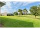 Home's green backyard provides a view of the green golf course and trees at 3587 Nw 55Th Cir, Ocala, FL 34482