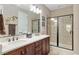 Bathroom featuring double sinks, dark wood cabinets, and a glass enclosed shower at 3587 Nw 55Th Cir, Ocala, FL 34482