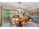 Open-concept dining area with hardwood floors and a sliding glass door providing access to the outdoor patio at 3587 Nw 55Th Cir, Ocala, FL 34482
