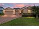 Charming home with a brick driveway, 2-car garage, stone accents, and meticulously maintained landscaping at 3587 Nw 55Th Cir, Ocala, FL 34482