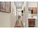 Hallway showing doors, artwork, and a glimpse into a laundry room with wood floors at 3587 Nw 55Th Cir, Ocala, FL 34482