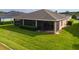 Back of home featuring a screened in porch, green lawn and manicured garden at 3587 Nw 55Th Cir, Ocala, FL 34482