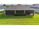 The back of the house features a screened in porch, green lawn and manicured garden at 3587 Nw 55Th Cir, Ocala, FL 34482