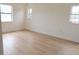 Bedroom with light wood-look flooring, white walls, and three windows providing ample natural light at 3807 Sw 143Rd Lane Rd, Ocala, FL 34473