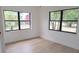 Bright bedroom with light wood-look flooring, neutral walls, and large windows with green views at 3807 Sw 143Rd Lane Rd, Ocala, FL 34473