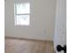 Bright bedroom featuring light wood-look flooring, white walls, and a window bringing in natural light at 3807 Sw 143Rd Lane Rd, Ocala, FL 34473