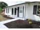 Inviting front porch showcasing fresh mulch, colorful flowers, and a freshly painted walkway and posts at 3807 Sw 143Rd Lane Rd, Ocala, FL 34473