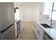 Kitchen with stainless steel appliances, white cabinets, gold hardware, light countertops, and light wood-look flooring at 3807 Sw 143Rd Lane Rd, Ocala, FL 34473