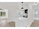 Stylish kitchen with white cabinets, stainless appliances, breakfast bar, and open view to the bathroom at 3807 Sw 143Rd Lane Rd, Ocala, FL 34473