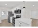 Bright kitchen featuring white cabinets, new appliances, and a stylish black pendant light at 3807 Sw 143Rd Lane Rd, Ocala, FL 34473