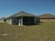 View of the home's back exterior, including a screened in porch and well-maintained lawn at 4373 Ne 31St St, Ocala, FL 34470