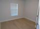 Bedroom featuring light wood floors, white walls, a window with blinds and white trim at 4373 Ne 31St St, Ocala, FL 34470