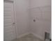 Bright laundry room featuring a wire rack shelf, utility sink access, and white door at 4373 Ne 31St St, Ocala, FL 34470