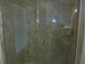 Close up of the bathroom shower featuring clear glass doors, grey tiles, and brushed nickel fixtures at 4373 Ne 31St St, Ocala, FL 34470