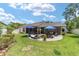 Spacious backyard with patio, manicured lawn, lush landscaping, and outdoor seating areas at 4404 Ne 4Th St, Ocala, FL 34470