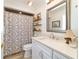 Well-lit bathroom featuring modern sink, decorative shelving and patterned shower curtain at 4404 Ne 4Th St, Ocala, FL 34470