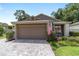 Single car garage with brick-paved driveway and tidy landscaping at 4404 Ne 4Th St, Ocala, FL 34470