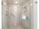 Glass-enclosed shower with tile surround, built-in niche, handheld shower, and grab bar at 4404 Ne 4Th St, Ocala, FL 34470