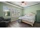 Cozy bedroom with plush bed, three bright windows, ceiling fan, and an armchair at 4721 Se 36Th St, Ocala, FL 34480