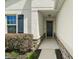 Inviting front entryway features a blue door, stone accents and well-maintained landscaping at 4721 Se 36Th St, Ocala, FL 34480
