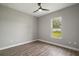 Cozy bedroom with ceiling fan, wood floors, and a window overlooking the backyard at 4743 Se 34Th St, Ocala, FL 34480