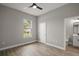 Bedroom with ceiling fan, wood floors, window and a view to an ensuite bathroom at 4743 Se 34Th St, Ocala, FL 34480