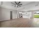 An open-concept living room boasts a stylish ceiling fan, wood floors, and seamless transition to the kitchen at 4743 Se 34Th St, Ocala, FL 34480