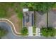 Aerial view of a home with solar panels, a driveway with two parked cars, and well-maintained landscaping at 5128 Grassy Knoll Dr, Tavares, FL 32778