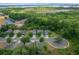 Community aerial view highlighting lush green trees, a nearby lake, and well-maintained homes at 5128 Grassy Knoll Dr, Tavares, FL 32778