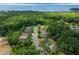 Aerial view of well-maintained homes surrounded by lush greenery, with a lake in the distance at 5128 Grassy Knoll Dr, Tavares, FL 32778