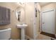 Cozy bathroom features a pedestal sink, a decorative oval mirror, and tiled flooring at 5128 Grassy Knoll Dr, Tavares, FL 32778
