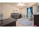 bedroom featuring a crib, alphabet rug, ceiling fan, and window with curtains at 5128 Grassy Knoll Dr, Tavares, FL 32778