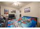 Bedroom with ceiling fan and comic-themed decor, featuring a large bed and wall art at 5128 Grassy Knoll Dr, Tavares, FL 32778