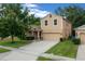Inviting two-story home with a well-kept lawn, mature tree, and a driveway to the attached garage at 5128 Grassy Knoll Dr, Tavares, FL 32778