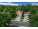 Aerial view of a two-story home surrounded by lush greenery and a spacious driveway at 5128 Grassy Knoll Dr, Tavares, FL 32778