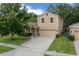 Charming two-story home featuring a well-manicured lawn and an attached two-car garage at 5128 Grassy Knoll Dr, Tavares, FL 32778
