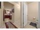 Hallway leading to the kitchen with light tile floor, and a door to a half bathroom at 5128 Grassy Knoll Dr, Tavares, FL 32778