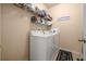 Functional laundry room featuring a side-by-side washer and dryer set with shelving above at 5128 Grassy Knoll Dr, Tavares, FL 32778